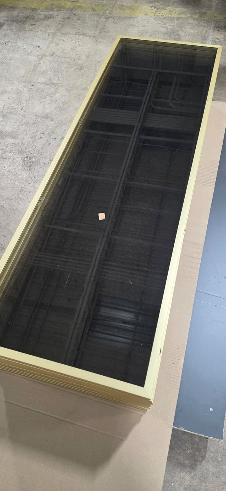 Stack of champagne anodized aluminum frame doors with bronze glass, ready for delivery