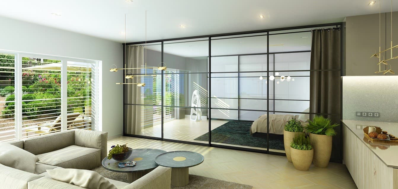 Black aluminum frame glass sliding doors dividing a living room and bedroom