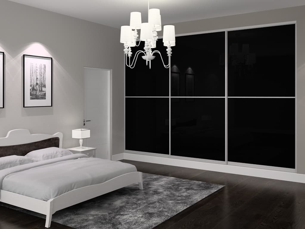 Black glass sliding closet doors in a bedroom